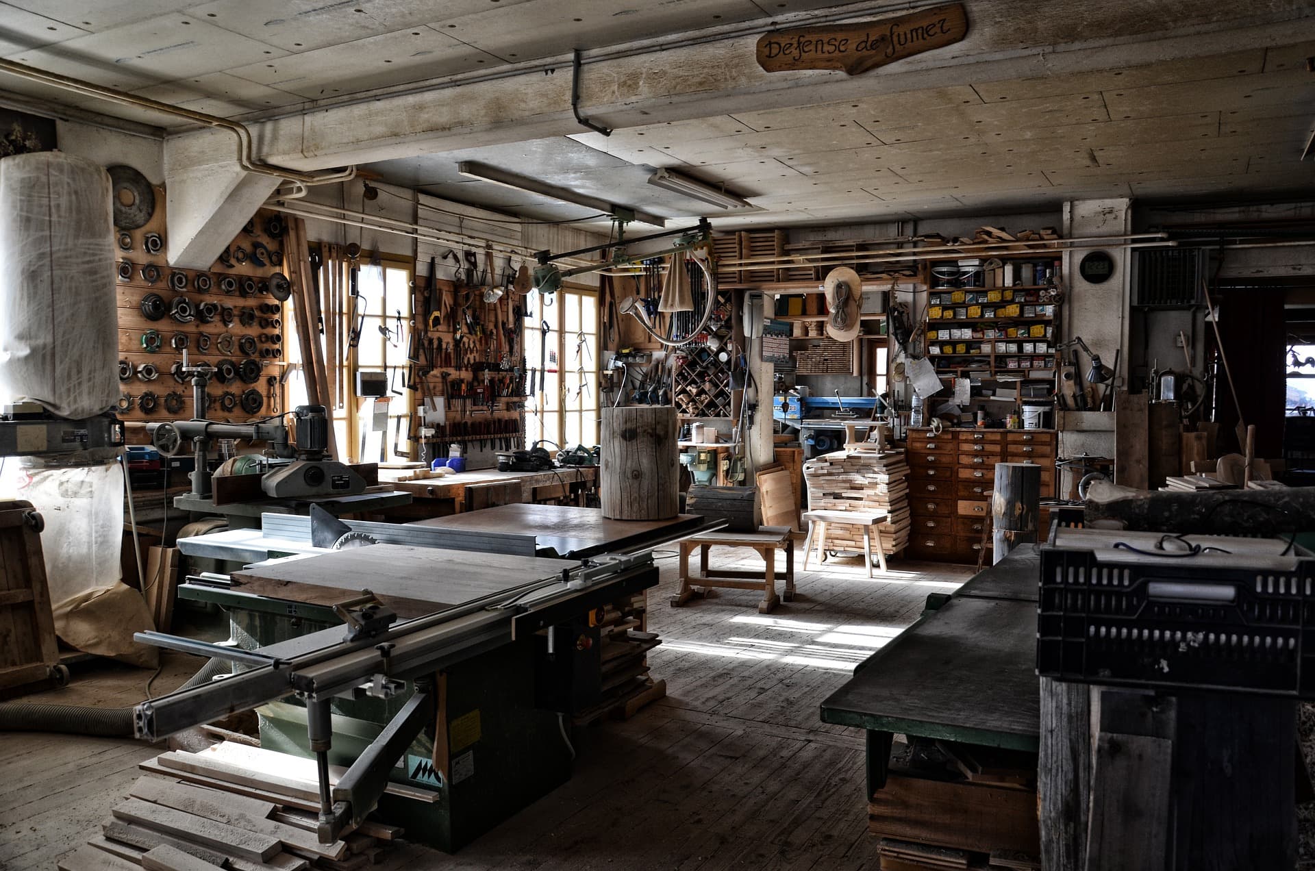 Interior of a woodworking shop filled with tools, wooden boards, and machinery.