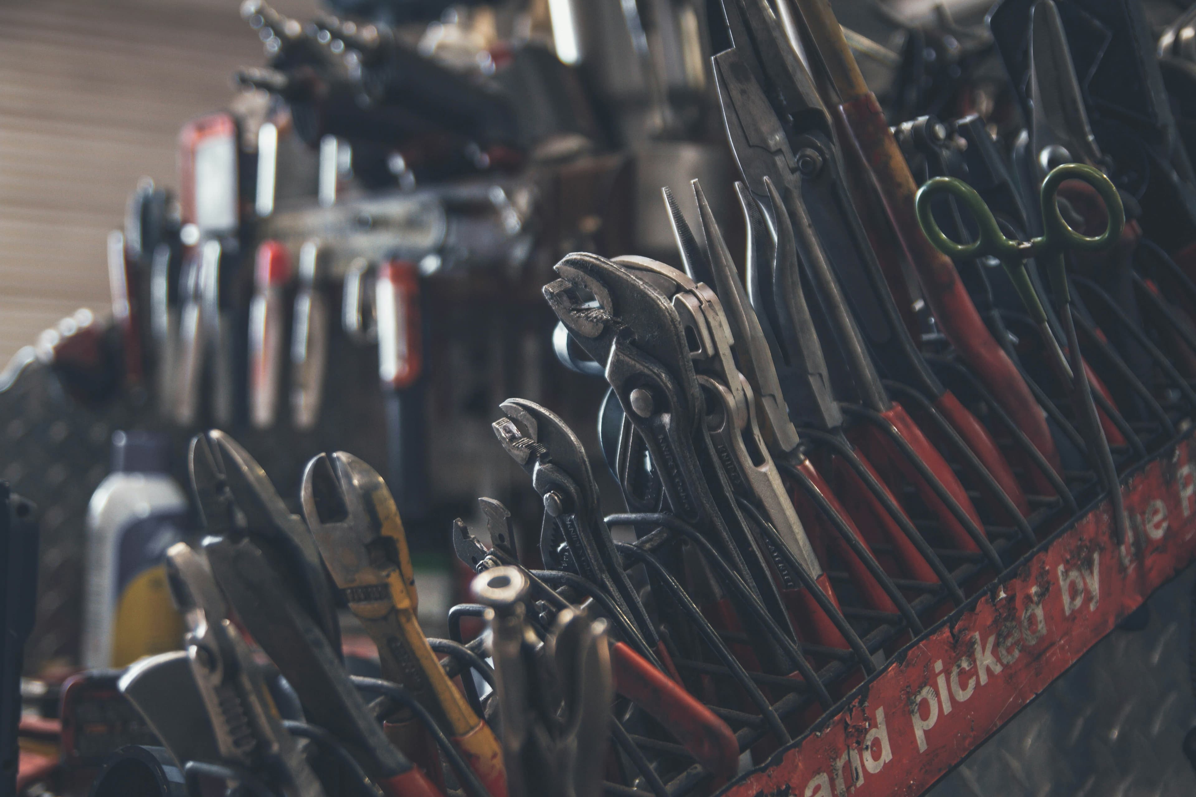 Assorted hand tools organised in a workshop rack.